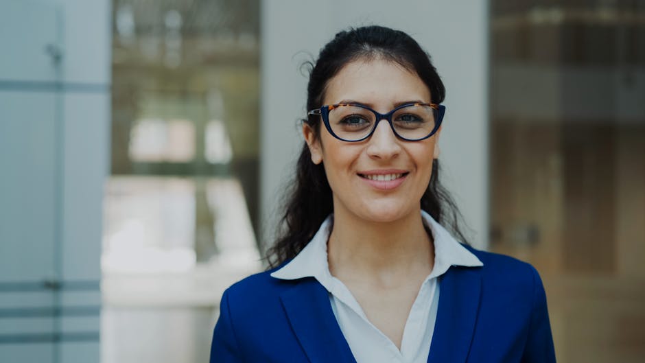 Portrait of a confident businesswoman in a blue suit standing indoors.