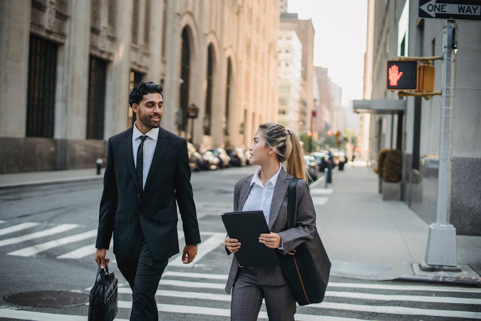 Two professionals in business attire discussing on a city street, exuding confidence and collaboration.